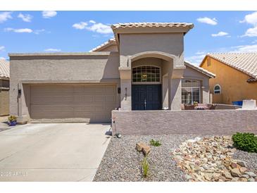 Charming home featuring desert landscaping, a covered porch and a two-car garage in a sunny neighborhood at 4762 E White Aster St, Phoenix, AZ 85044