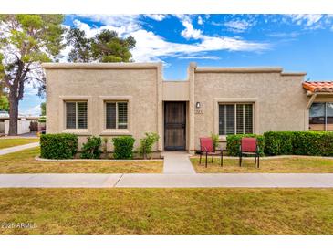 Charming single-story home featuring a stucco exterior, manicured front yard, and cozy patio chairs at 5037 N 81St St, Scottsdale, AZ 85250
