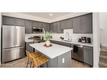 Modern kitchen features gray cabinets, stainless steel appliances, and a center island with seating at 5518 S Dillon Cir, Mesa, AZ 85212