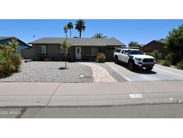 Charming single-story home features desert landscaping, a neutral color scheme and a paved walkway to the front door at 711 W El Alba Way, Chandler, AZ 85225
