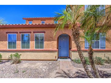 Charming home featuring a blue front door, lush palm trees and desert landscaping at 7242 S 48Th Gln, Laveen, AZ 85339