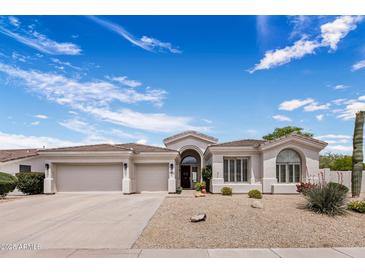Charming single-story home with a three-car garage, desert landscaping and a tile roof at 7492 E Buteo Dr, Scottsdale, AZ 85255