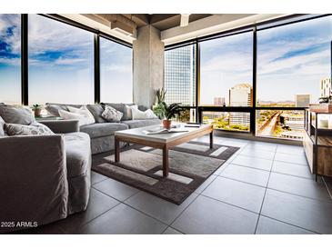 Bright living room featuring floor-to-ceiling windows with a stunning city view and comfortable seating at 1 E Lexington Ave # 1209, Phoenix, AZ 85012
