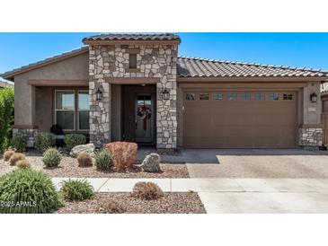 Charming single-story home featuring a stone facade, tile roof, and well-maintained landscaping at 10029 E Wavelength Ave, Mesa, AZ 85212