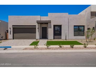 Contemporary home with a two-car garage, desert landscaping, and a clean, modern facade at 10332 E Utah Ave, Mesa, AZ 85212