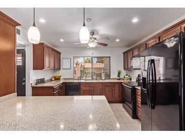 Well-lit kitchen featuring granite countertops, wood cabinets, and stainless steel appliances at 129 Leisure World --, Mesa, AZ 85206