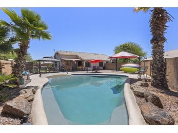 Inviting backyard oasis with a sparkling pool, lush landscaping, and resort-style amenities for relaxation and entertainment at 1518 E 12Th St, Casa Grande, AZ 85122