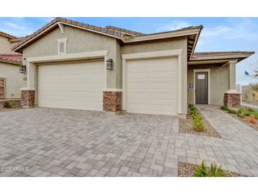 Charming home featuring a two-car garage and an attractive brick driveway and pillars for a sophisticated look at 19420 W San Juan Ave, Litchfield Park, AZ 85340