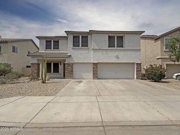 Charming two-story home boasts a three car garage, low maintenance landscaping and a welcoming front porch at 19432 W Morning Glory Dr, Buckeye, AZ 85326