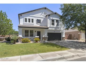 Charming two-story home featuring a well-manicured lawn, covered porch, and a two-car garage at 2562 E Los Alamos St, Gilbert, AZ 85295