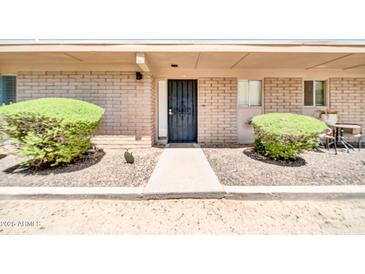 Charming front entrance with well-maintained landscaping and a secure black security door at 27250 N 64Th St # 16, Scottsdale, AZ 85266