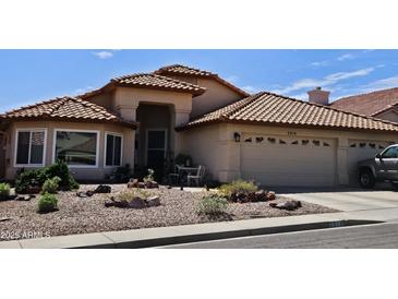 Charming single-story home featuring a tile roof, desert landscaping, and a cozy front patio at 2919 E Friess E Dr, Phoenix, AZ 85032