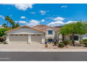 Charming home featuring a three-car garage, desert landscaping, and a pristine stucco exterior under a sunny sky at 5510 W Arrowhead Lakes Dr, Glendale, AZ 85308
