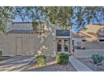 Charming townhouse featuring a private front entrance, landscaped with desert foliage, and a tiled roof at 602 N May -- # 23, Mesa, AZ 85201