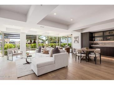 Bright living room featuring a white couch, wood floors, and large windows with a view at 7137 E Rancho Vista Dr # 4011, Scottsdale, AZ 85251