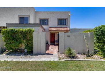 Charming two-story home with a red tile entry, desert landscaping, and an enclosed front yard at 7808 E Valley Vista Dr, Scottsdale, AZ 85250