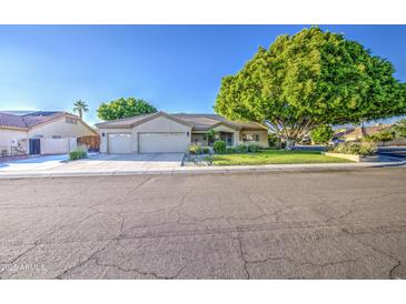 Charming single-Gathering home featuring a well-maintained lawn and a three car garage at 8748 W Maui Ln, Peoria, AZ 85381