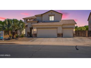Charming two-story home with three-car garage, tile roof, and desert landscaping at 11003 E Ravenna Cir, Mesa, AZ 85212
