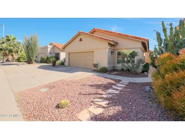 Charming single-story home features a two-car garage and low-maintenance desert landscaping at 13584 N 102Nd Pl, Scottsdale, AZ 85260