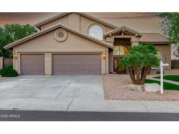 Charming home featuring a three-car garage, desert landscaping, and an arched entryway at 15237 S 19Th Way, Phoenix, AZ 85048