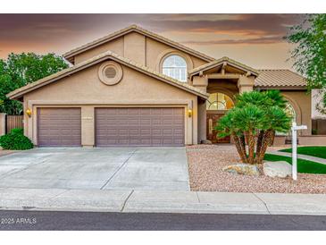 Charming home featuring a desert landscaped front yard, large garage, and covered entryway at 15237 S 19Th Way, Phoenix, AZ 85048