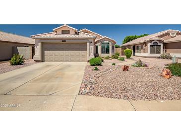Charming single-story home with a well-maintained desert landscape and a two-car garage at 15558 N Ulrich Way, Surprise, AZ 85374