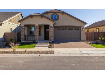 Charming single-story home with a well-manicured lawn and a two-car garage at 20073 S 231St Pl, Queen Creek, AZ 85142