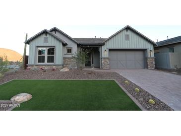 Charming single-story home with well-manicured lawn and stone accents at 32541 N 135Th Dr, Peoria, AZ 85383
