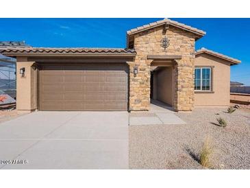 Inviting home featuring a two-car garage and stone facade at 39980 W Bunker Dr, Maricopa, AZ 85138
