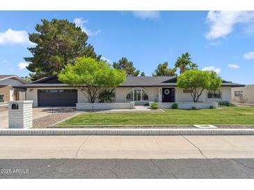 Charming single-story home with manicured lawn, mature trees, and a brick facade at 401 E Braeburn Dr, Phoenix, AZ 85022
