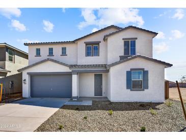 Charming two-story home featuring a gray two-car garage and well-maintained landscaping at 5881 N 193Rd Dr, Litchfield Park, AZ 85340