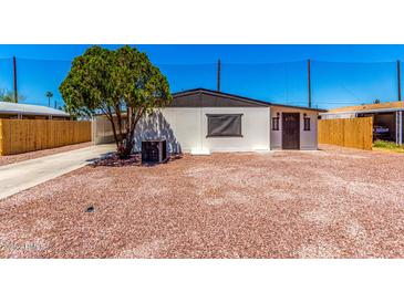 Charming home featuring a low maintenance yard, complemented by desert landscaping and mature shade tree at 7442 E Baseline Rd, Mesa, AZ 85209