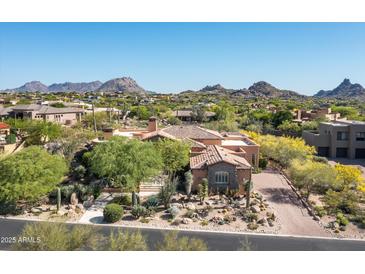 Stunning view of a desert home showcasing clay tile roof and beautiful desert landscaping at 10531 E Cinder Cone Trl, Scottsdale, AZ 85262