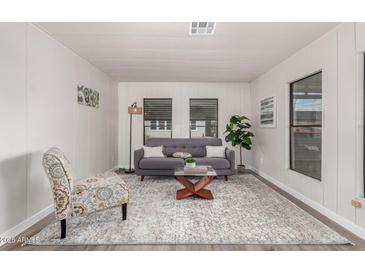 Inviting living room featuring neutral walls, grey sofa, and bright natural light at 11000 N 91St Ave # 101, Peoria, AZ 85345