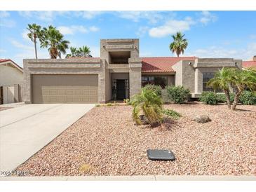 Charming single-story home featuring a low-maintenance desert landscape and a welcoming two-car garage at 11106 E Clinton St, Scottsdale, AZ 85259
