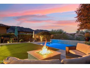 Serene backyard retreat showcasing a pool, fire pit, outdoor seating, and mountain views at sunset at 15711 S 11Th Ave, Phoenix, AZ 85045
