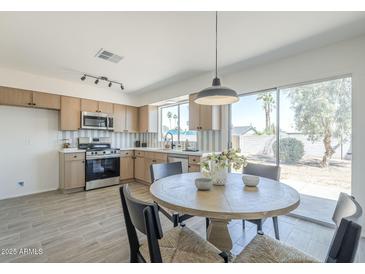 Bright kitchen with stainless steel appliances and a cozy dining area with sliding glass doors to outdoor space at 1708 W Estrella Dr, Chandler, AZ 85224