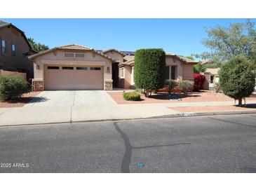 Charming single-story home with a well-manicured front yard, desert landscaping, and a two-car garage at 17516 W Pershing St, Surprise, AZ 85388