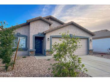 Charming single-story home featuring a well-maintained front yard with gravel and a two-car garage at 22755 W Yavapai St, Buckeye, AZ 85326