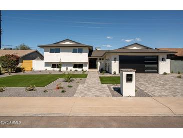 Beautiful two-story home featuring a manicured lawn and stylish gray brick walkway, creating a welcoming entrance at 3413 N 87Th Pl, Scottsdale, AZ 85251