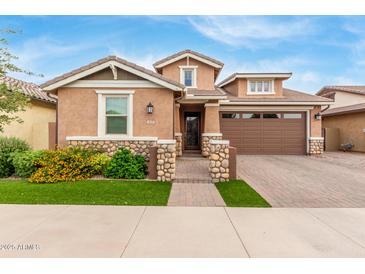 Charming two-story home featuring a stone facade, landscaped yard, and brick driveway for added curb appeal at 3637 E Ebano St, Gilbert, AZ 85295
