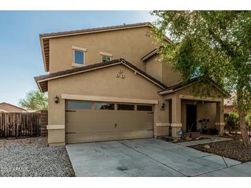 Charming two-story home featuring a well-maintained front yard with a two car garage at 7090 S 252 Dr, Buckeye, AZ 85326