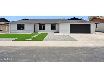 Charming, single-story home featuring updated brickwork, a dark roof, attached garage, and green synthetic front lawn at 1030 E Wescott Dr, Phoenix, AZ 85024