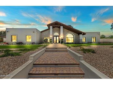Stunning home exterior with a brick walkway and desert landscaping at 10755 E Cholla Ln, Scottsdale, AZ 85259