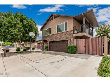 Charming two-story home featuring a stone facade, balcony, basketball court and well-maintained landscaping at 1121 W Mission Dr, Chandler, AZ 85224