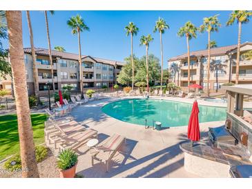 Resort style pool and sun deck surrounded by tall palm trees and lush landscaping at 14950 W Mountain View Blvd # 2210, Surprise, AZ 85374
