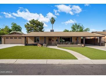 Charming single-story home with a well-manicured lawn, welcoming walkway, and palm tree under a partly cloudy sky at 1640 E Solano Dr, Phoenix, AZ 85016