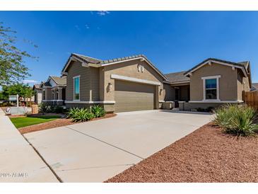 Charming single-story home showcasing a wide driveway and a two-car garage at 21031 E Poco Calle St, Queen Creek, AZ 85142