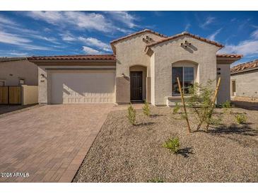 Inviting single-story home featuring a neatly paved driveway and low maintenance desert landscaping at 262 S 164Th Dr, Goodyear, AZ 85338