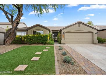 Charming single-story home with well-maintained landscaping, stone pathway, and attached two-car garage at 26264 N 46Th St, Phoenix, AZ 85050